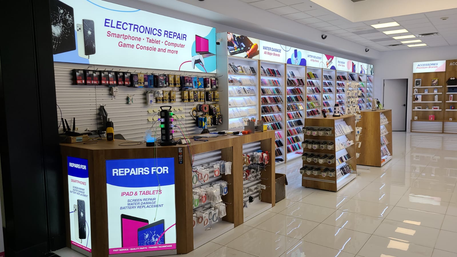 Full The Fix retail store buildout by BD Display in St. Louis — illuminated case wall, repair counter, and accessory tables