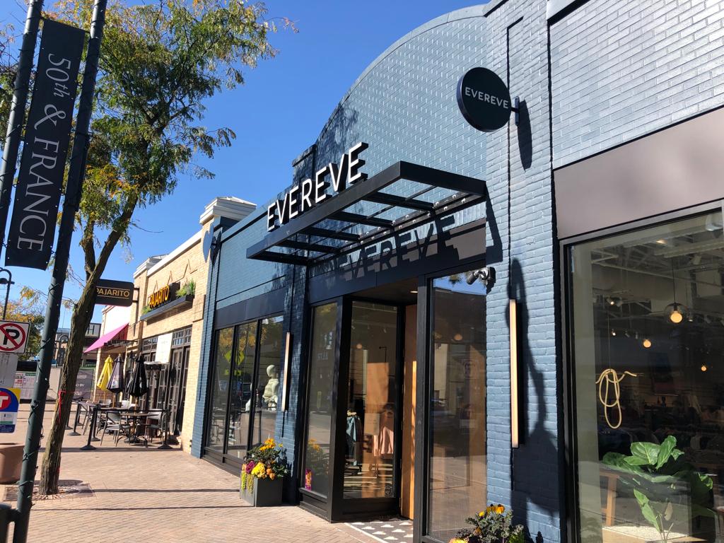 Evereve storefront — channel-letter wordmark and circular blade sign at 50th & France