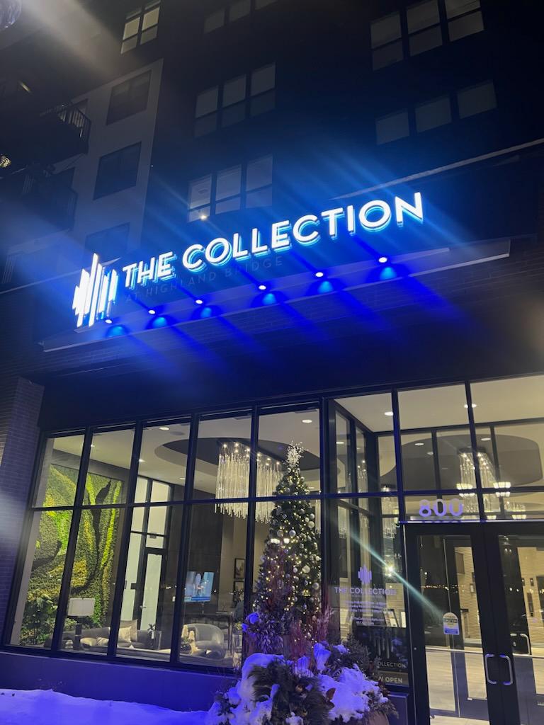 The Collection at Highland Bridge — illuminated channel-letter sign with blue down-light wash